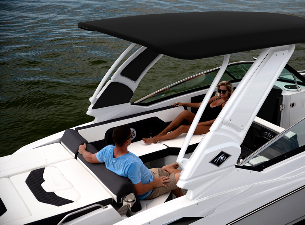 People relaxing in the shaded cockpit seating area of a Monterey boat on the water.